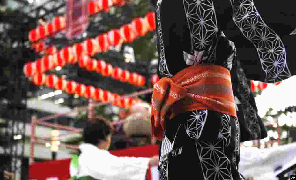 A woman dances in "bon-odori," a traditional summer dance at a festival in Tokyo. The festival is held to celebrate and promote such Japanese traditions to help the city cool down.