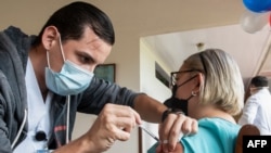 Un trabajador de la salud administra una vacuna COVID-19 a una anciana en el Centro de Residencia Geriátrica Casa Israel en Cartago, Costa Rica, el 12 de enero de 2020.