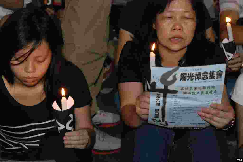 參與六四25周年燭光集會的民眾,看著場刊印上的歌詞唱民運歌曲