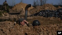 Український військовослужбовець відпочиває від риття окопів на позиції. AP Photo/Vadim Ghirda