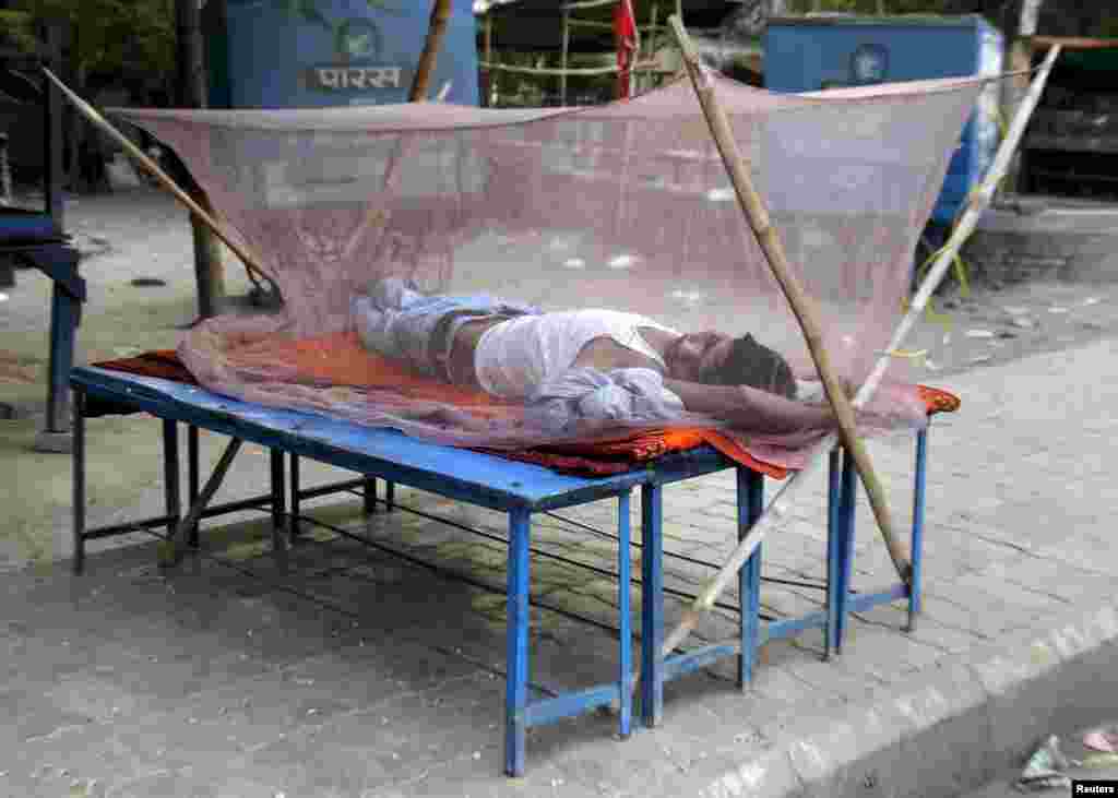 A man sleeps on a makeshift bed covered with a mosquito net on a hot summer morning in Allahabad where it is expected to reach 47 degrees Celsius according to India's metrological department, June 1, 2015. 