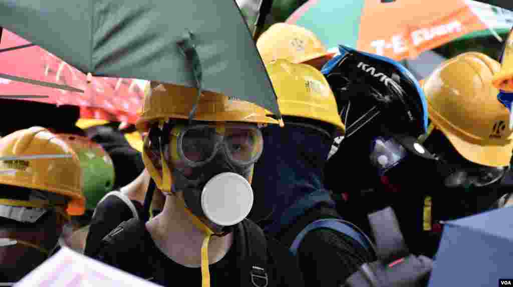 沙田反送中大遊行爆發源禾路警民衝突後,示威者戴上頭盔、眼罩及防毒面具等全副裝備,在防線內與防暴警察對峙。(美國之音湯惠芸拍攝)
