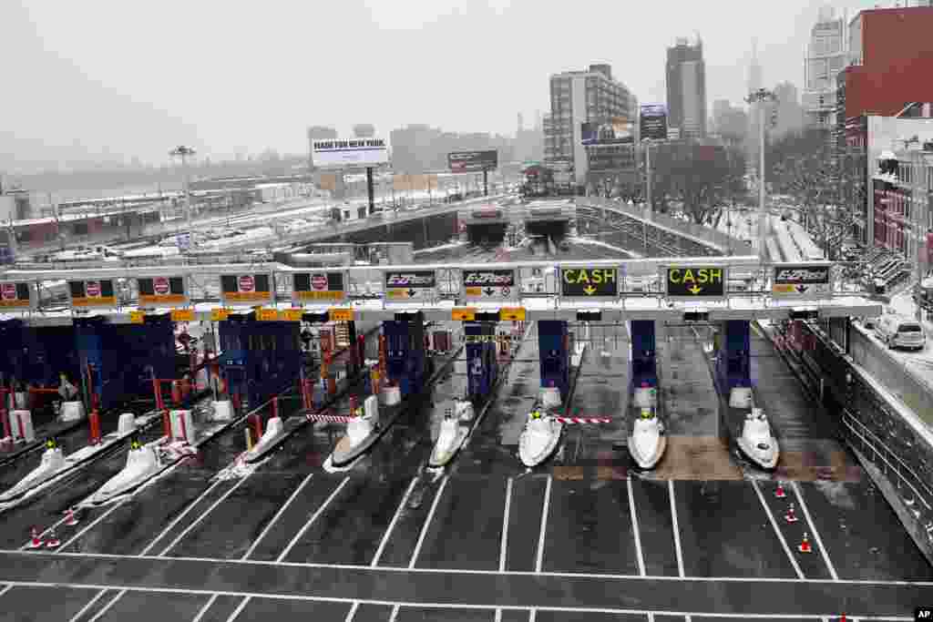 Gerbang tol yang kosong di pagi hari setelah badai salju di Queens, New York (27/1). (AP/Jason DeCrow)