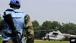 Un Casque bleu gardant un hélicoptère de l'ONU , à Abidjan