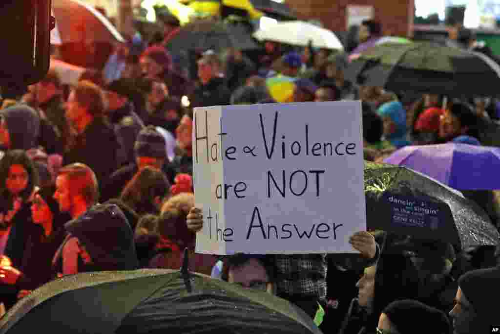 Мальчик держит плакат с надписью "Ненависть и насилие - не ответ" ("Hate and violence are not the answer") во время мемориального бдения в районе Скуиррел-Хилл в Питтсбурге в память о погибших в результате стрельбы в синагоге "Л'Симха" (фото: AP / Gene J. Puskar, 27 октября)