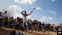Un manifestant palestinien jette des pierres aux soldats israéliens dans l’est de Gaza, le 9 octobre 2015