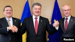 Ukraine's President Petro Poroshenko poses with European Commission President Jose Manuel Barroso (L) and European Council President Herman Van Rompuy (R) at the EU Council in Brussels, June 27, 2014.