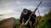 A Syrian insurgent dashes for cover as rebel forces take control of a Syrian Arab Republic military academy in Aleppo in December 2012. 