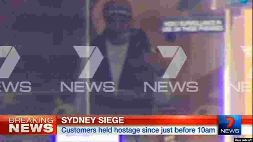 This image taken from video shows a man believed to be a gunman inside a cafe in Sydney, Australia, Dec. 15, 2014.