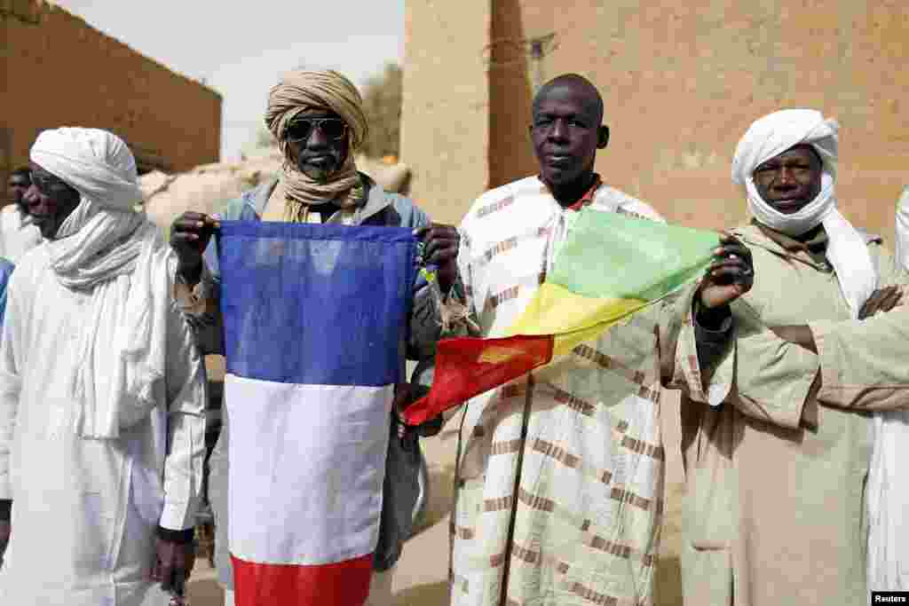 People hold Malian and French flags during the reopening ceremony of Mahamane Fondogoumo elementary school in the town center of Timbuktu, February 1, 2013. 