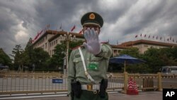 Seorang prajurit Tentara Pembebasan Rakyat China (PLA) yang mengenakan masker saat melarang fotografer memotret di depan Balai Besar Rakyat China di Beijing, 25 Mei 2020. (AP)