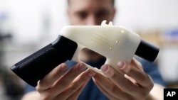 FILE - Cody Wilson, with Defense Distributed, holds a 3D-printed gun called the Liberator at his shop in Austin, Texas, Aug. 1, 2018.