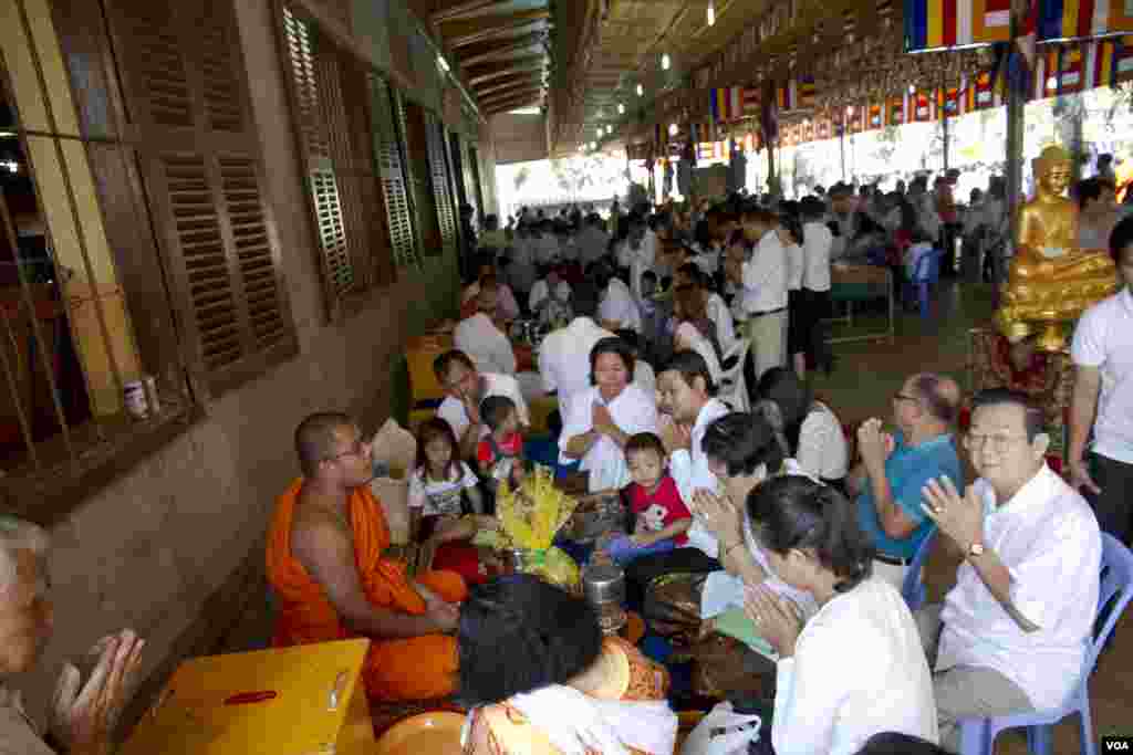 ក្រុមគ្រួសារខ្មែរដែលជាអ្នកកាន់ពុទ្ធសាសនា ប្រគេនចង្ហាន់និងទេយ្យទានគ្រឿងបរិក្ខាបង្សុកូលជូនដល់បុព្វការីជនរបស់ខ្លួន។