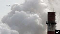 ARCHIVO-Un avión comercial de pasajeros vuela cerca de un planta de energía por carbón en Beijing, China. 28-2-17.