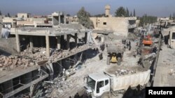 Residents inspect damage at a site hit by one of three explosive trucks, in the YPG-controlled town of Tel Tamer, Syria, Dec. 11, 2015. 