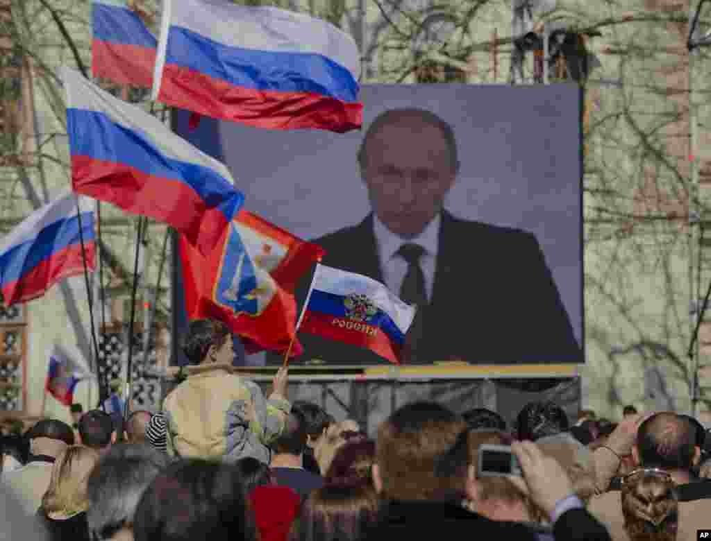 A pro-Russian crowd watches a live broadcast of Russian President Vladimir Putin's speech on Crimea, in Sevastopol, Crimea, Ukraine, March 18, 2014. 