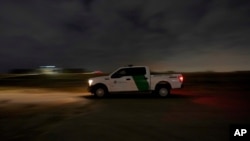 A U.S. Customs and Border Protection truck drives by a road adjacent to the U.S.-Mexico border, March 22, 2021, in Hidalgo, Texas. 