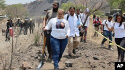 Ceci Flores, líder de un grupo de "madres en busca" del norte de México, lleva una pala al lugar donde, según dijo, su equipo encontró un crematorio clandestino en Tláhuac, en las afueras de la Ciudad de México, el miércoles 1 de mayo de 2024. 