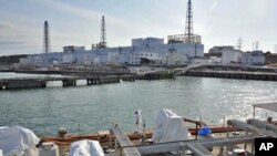 A US military barge carrying pure water (bottom) leaves the quay near Tokyo Electric Power Co.'s Fukushima Daiichi Nuclear Power Plant, April 4, 2011