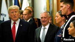 El secretario de Defensa de EE.UU., James Mattis, (derecha) escolata al presidente Donald Trump mientras saluda al personal militar durante su visita al Pentágono el jueves, 20 de julio de 2017.