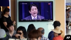 首爾列車站的人群觀看日本首相就日本二戰投降70週年發表談話。（2015年8月14日）