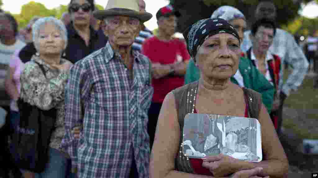 Une femme tenant en main une photo du défunt Fidel Castro et du défunt président vénézuélien Hugo Chavez, dans la Place de la Révolution pour rendre hommage à Fidel Castro, à La Havane, Cuba, le 28 novembre 2016.