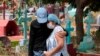 Dos nicaragüenses asisten al funeral de un hombre que se sospecha murió de coronavirus. Las pruebas para confirmar la enfermedad son escasas en Nicaragua.