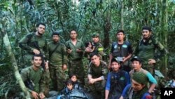 En esta foto difundida por la Oficina de Prensa de las Fuerzas Armadas de Colombia soldados e indígenas posan con los cuatro hermanos que llevaban 40 días desaparecidos en la selva de Solano, estado de Caquetá, Colombia, el viernes 9 de junio de 2023. 