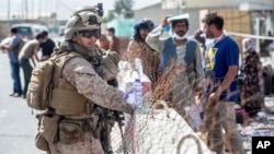 Marinac iz odreda za odgovore u kriznim situacijama (SPMAGTF-CR-CC) pomaže pri evakuaciji na aerodromu Hamid Karzai u Kabulu, Avganistan, 21. avgusta 2021.