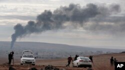 Asap membumbung setelah serangan udara di Kobani, Suriah, dalam pertempuran antara Kurdi dan militan Negara Islam atau ISIS, 19 Oktober 2014.