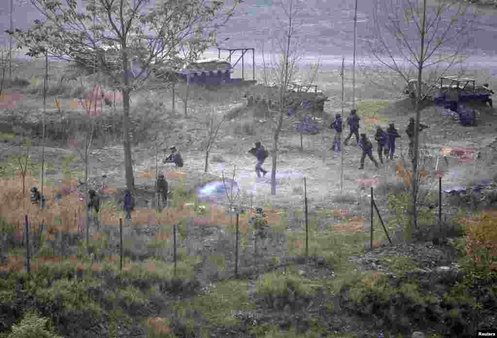 Indian army soldiers search for suspected militants as smoke rises from a bunker after a gunbattle in Mohra in Uri, December 5, 2014.