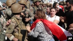 Anti-government protesters scuffle with Lebanese army soldiers in the town of Zouk Mosbeh, north of Beirut, Lebanon, Nov. 5, 2019.