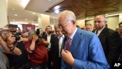 FILE - Former Malaysian Prime Minister Najib Razak, center, is pictured in the courthouse in Kuala Lumpur, Malaysia, Dec. 3, 2019.