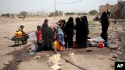 FILE - People fill buckets with water from a well that is alleged to be contaminated water with the bacterium Vibrio cholera, on the outskirts of Sanaa, Yemen, Jul. 12, 2017.