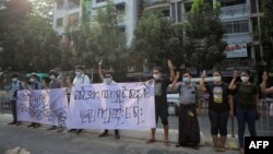 Protesters hold up a three-finger salute during a rally against the military coup in Yangon on February 5, 2021. 