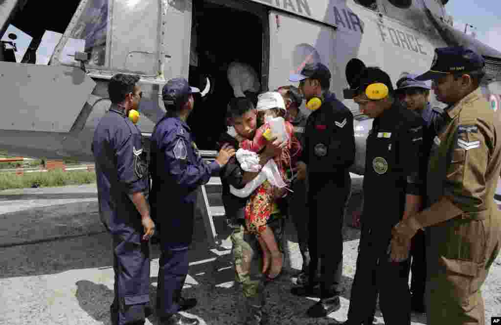 A child injured in Saturday’s earthquake, is carried by a Nepalese soldier after being evacuated in an Indian Air Force helicopter at the airport in Kathmandu, Nepal.