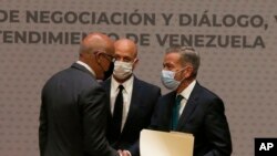 ARCHIVO - El presidente de la Asamblea Nacional de Venezuela, Jorge Rodríguez, a la izquierda, estrecha manos con el delegado de la oposición venezolana Gerardo Blyde Pérez en Ciudad de México, el 13 de agosto de 2021. 