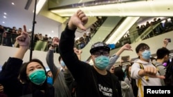 2月15日，香港一个购物中心里，港人与大陆游客发生摩擦。抗议者向陆客作出手势，表示不满。