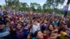 Partidarios piden regalos durante un mitin de campaña del partido Cabal mientras esperan a su candidato presidencial Edmond Mulet en San Juan Sacatepéquez, Guatemala, el domingo 18 de junio de 2023. Los guatemaltecos acuden a las urnas el 25 de junio. (Foto AP/Moises Castillo )