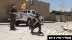 Seorang pejuang Kurdi mengumpulkan bukti bekas-bekas senjata mortir ISIS yang diduga berisi senjata kimia di Hasaka, Suriah (foto: dok).