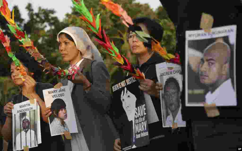 Aktivis Indonesia memegang foto tahanan, yang merupakan terpidana mati kasus narkoba, dalam sebuah demo yang menuntut pemerintah menghentikan eksekusi mereka, di Jakarta, Indonesia, 28 April 2015. 