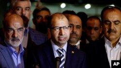 Le président du Parlement irakien Salim al-Jabouri, au centre, parle aux journalistes lors d'une conférence de presse à Bagdad, en Irak, le 13 Avril 2016. (AP Photo/Karim Kadim) 