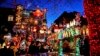 Turis melihat rumah yang dihiasi lampu Natal di kawasan Dyker Heights, Brooklyn, New York, Rabu, 21 Desember 2022. (Julia Nikhinson/AP)
