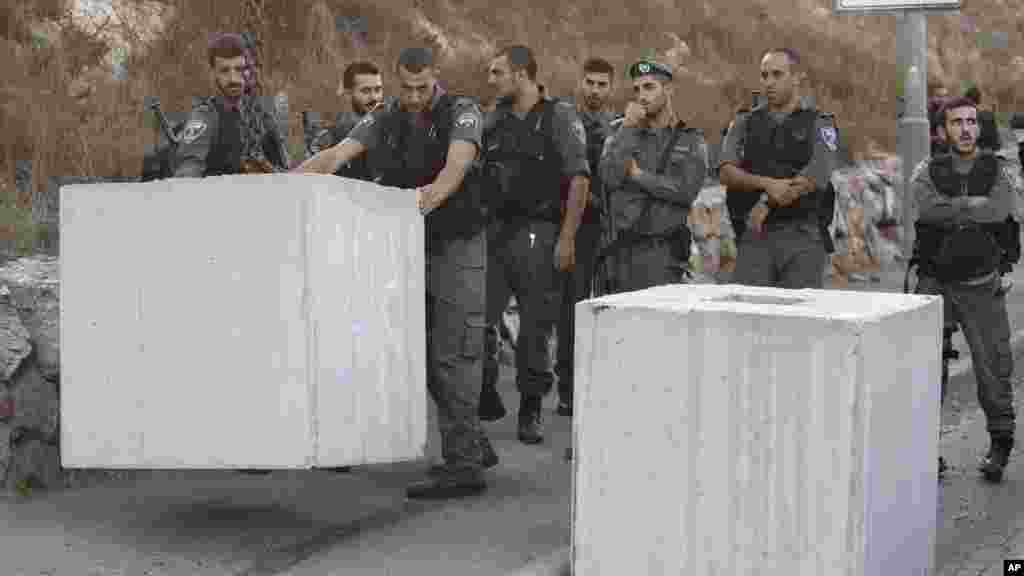 'Yan Sanda masu gadin Iyakar Isira'ila na caje wani bafalastine, kusa da wani sabon guri da aka gina dake gabashin unguwar Jerusalem. 
