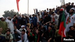 People chant slogans as they block main highway during a protest to condemn the shooting incident on a long march held by Pakistan's former Prime Minister Imran Khan, in Wazirabad, Pakistan Nov. 4, 2022. 