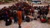 Migrantes hacen fila para abordar un autobús luego de aceptar una oferta del gobierno mexicano para obtener visas humanitarias para transitar por territorio mexicano, en Tapachula, México, el 4 de diciembre de 2021. 