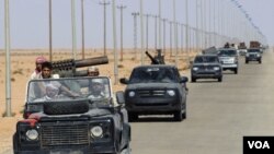 Para pejuang pemberontak Libya mengendarai kendaraan militer mereka di sebelah timur Bani Walid menjelang tenggat bagi loyalis pro-Gaddafi untuk menyerah (8/9).