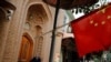 Ilustrasi - Seorang pria tua terlihat di belakang bendera nasional China di Kota Tua Kashgar di Daerah Otonomi Uyghur, Xinjiang, China, 6 September 2018. (REUTERS/Thomas Peter)