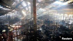 FILE - Firefighters try to control a fire in a garment factory in Gazipur, Bangladesh, Oct. 9, 2013. 