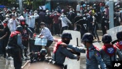 Protesters run after police fire warning-shots and use water cannons to disperse them during a protest in Mandalay, Myanmar on Feb. 9, 2021.